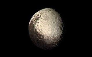 <h1>PIA00348:  Iapetus Bright and Dark Terrains</h1><div class="PIA00348" lang="en" style="width:325px;text-align:left;margin:auto;background-color:#000;padding:10px;max-height:150px;overflow:auto;">Saturn's outermost large moon, Iapetus, has a bright, heavily cratered icy terrain and a dark terrain, as shown in this Voyager 2 image taken on August 22, 1981. Amazingly, the dark material covers precisely the side of Iapetus that leads in the direction of orbital motion around Saturn (except for the poles), whereas the bright material occurs on the trailing hemisphere and at the poles. The bright terrain is made of dirty ice, and the dark terrain is surfaced by carbonaceous molecules, according to measurements made with Earth-based telescopes. Iapetus' dark hemisphere has been likened to tar or asphalt and is so dark that no details within this terrain were visible to Voyager 2. The bright icy hemisphere, likened to dirty snow, shows many large impact craters. The closest approach by Voyager 2 to Iapetus was a relatively distant 600,000 miles, so that our best images, such as this, have a resolution of about 12 miles. The dark material is made of organic substances, probably including poisonous cyano compounds such as frozen hydrogen cyanide polymers. Though we know a little about the dark terrain's chemical nature, we do not understand its origin. Two theories have been developed, but neither is fully satisfactory--(1) the dark material may be organic dust knocked off the small neighboring satellite Phoebe and "painted" onto the leading side of Iapetus as the dust spirals toward Saturn and Iapetus hurtles through the tenuous dust cloud, or (2) the dark material may be made of icy-cold carbonaceous "cryovolcanic" lavas that were erupted from Iapetus' interior and then blackened by solar radiation, charged particles, and cosmic rays. A determination of the actual cause, as well as discovery of any other geologic features smaller than 12 miles across, awaits the Cassini Saturn orbiter to arrive in 2004.<br /><br /><a href="http://photojournal.jpl.nasa.gov/catalog/PIA00348" onclick="window.open(this.href); return false;" title="Voir l'image 	 PIA00348:  Iapetus Bright and Dark Terrains	  sur le site de la NASA">Voir l'image 	 PIA00348:  Iapetus Bright and Dark Terrains	  sur le site de la NASA.</a></div>
