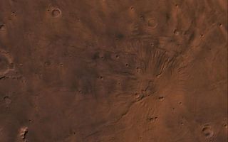 <h1>PIA00421:  Tyrrhena Patera</h1><div class="PIA00421" lang="en" style="width:800px;text-align:left;margin:auto;background-color:#000;padding:10px;max-height:150px;overflow:auto;"><p>A color image of the Tyrrhena Patera Region of Mars; north toward top. The scene shows a central circular depression surrounded by circular fractures and highly dissected horizontal sheets. A patera (Latin for shallow dish or saucer) is a volcano of broad areal extent with little vertical relief.</p>This image is a composite of Viking medium-resolution images in black and white and low-resolution images in color. The image extends from latitude 17 degrees S. to 25 degrees S. and from longitude 250 degrees to 260 degrees; Mercator projection.</p>Tyrrhena Patera has a 12-km-diameter caldera at its center surrounded by a 45-km-diameter fracture ring. Around the fracture ring, the terrain is highly eroded forming ragged outward-facing cliffs, as though successive flat-lying layers had been eroded back. Cut into the sequence are several flat-floored channels that extend outward as far as 200 km from the center of the volcano. The structure may be composed of highly erodible ash layers and the channels may be fluvial, with the release of water being triggered by volcanic activity (Carr, 1981, The surface of Mars, Yale Univ. Press, New Haven, 232 p.).<br /><br /><a href="http://photojournal.jpl.nasa.gov/catalog/PIA00421" onclick="window.open(this.href); return false;" title="Voir l'image 	 PIA00421:  Tyrrhena Patera	  sur le site de la NASA">Voir l'image 	 PIA00421:  Tyrrhena Patera	  sur le site de la NASA.</a></div>