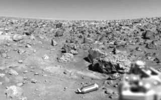 <h1>PIA00527:  Ejected Shroud on the Martian Surface</h1><div class="PIA00527" lang="en" style="width:517px;text-align:left;margin:auto;background-color:#000;padding:10px;max-height:150px;overflow:auto;">Shining on the Martian surface near the Viking 2 spacecraft is the aluminum shroud, or cover, which protected the collector head of the surface sampler instrument during Viking's year-long journey from Earth. On September 5, two days after Viking 2 landed, the surface sampler was rotated from its parked position atop the spacecraft and pointed downward about 40 degrees. The shroud was then ejected by a set of eight springs positioned around its base. It struck the porous rock at the bottom of the picture, bounced about 20 inches, hit the surface again and bounced another 20 inches. The scar left by the second bounce is faintly visible halfway between the shroud and the rock it struck. The shroud is 12 inches long and 4 1/2 inches in diameter. The large rock just beyond it is about 2 feet long and about a foot thick. At lower right is the support structure of one of the spacecraft s three landing legs.<br /><br /><a href="http://photojournal.jpl.nasa.gov/catalog/PIA00527" onclick="window.open(this.href); return false;" title="Voir l'image 	 PIA00527:  Ejected Shroud on the Martian Surface	  sur le site de la NASA">Voir l'image 	 PIA00527:  Ejected Shroud on the Martian Surface	  sur le site de la NASA.</a></div>