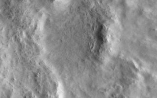 <h1>PIA01330:  Fluidized Crater Ejecta Deposit</h1><div class="PIA01330" lang="en" style="width:800px;text-align:left;margin:auto;background-color:#000;padding:10px;max-height:150px;overflow:auto;">The Mars Orbiter Camera (MOC) onboard the Mars Global Surveyor (MGS) spacecraft continued to obtain high resolution images of the red planet into August 1998. At this time, each ground track (the portion of Mars available for MOC imaging on a given orbit) covers areas from about 40°N on the late afternoon side of the planet, up over the sunlit north polar cap, and down the early morning side of Mars to about 20°N latitude. Early morning and late afternoon views provide good shadowing to reveal subtle details on the martian surface. Views of Mars with such excellent lighting conditions will not be seen by MOC once MGS's Science Phasing Orbits end in mid-September 1998.<p>The image shown here, MOC image 47903, was targeted on Friday afternoon (PDT), August 7, 1998. This picture of ejecta from a nameless 9.1 kilometer (5.7 mile)-diameter crater was designed to take full advantage of the present lighting conditions. When the image was taken (around 5:38 p.m. (PDT) on Saturday, August 8, 1998), the Sun had just risen and was only about 6° above the eastern horizon. With the Sun so low in the local sky, the contrast between sunlit and shadowed surfaces allowed new, subtle details to be revealed on the surface of the crater ejecta deposit.<p>The crater shown here has ejecta of a type that was first identified in Mariner 9 and Viking Orbiter images as "fluidized" ejecta. Ejecta is the material that is thrown out from the crater during the explosion that results when a meteor--piece of a comet or asteroid--collides with the planet. Fluidized ejecta is characterized by its lobate appearance, and sometimes by the presence of a ridge along the margin of the ejecta deposit. In the case of the crater shown here, there are two ridges that encircle the crater ejecta--this type of ejecta deposit is sometimes called a double-lobe rampart deposit. The MOC image shows that this particular crater also has "normal" ejecta that occurs out on the plains, beyond the outermost ridge of the main, fluidized ejecta deposit.<p>Fluidized or "rampart" ejecta deposits have long been thought by many Mars scientists to result from an impact into a surface that contains water. The water would have been underground, and could have been frozen or liquid. According to the prevailing model, when the meteor hit, this water was released--along with tons of rock and debris--and the ejecta flowed like mud. Images with resolutions higher than those presently attainable from the 11.6 hr elliptical orbit are needed to see the specific features (such as large boulders "rafted" by the dense mud) that would confirm or refute this model. Such images may be acquired once MGS is in its mapping orbit.<p>MOC image 47903 was received and processed by the MOC team at Malin Space Science Systems on Monday afternoon (PDT), August 10, 1998. The image center is located at 27.92°N latitude and 184.66°W longitude, in the northern Tartarus Montes region.<br /><br /><a href="http://photojournal.jpl.nasa.gov/catalog/PIA01330" onclick="window.open(this.href); return false;" title="Voir l'image 	 PIA01330:  Fluidized Crater Ejecta Deposit	  sur le site de la NASA">Voir l'image 	 PIA01330:  Fluidized Crater Ejecta Deposit	  sur le site de la NASA.</a></div>