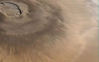 <h1>PIA01476:  Olympus Mons, 1998 (color)</h1><div class="PIA01476" lang="en" style="width:573px;text-align:left;margin:auto;background-color:#000;padding:10px;max-height:150px;overflow:auto;">Olympus Mons is a mountain of mystery. Taller than three Mount Everests and about as wide as the entire Hawaiian Island chain, this giant volcano is nearly as flat as a pancake. That is, its flanks typically only slope 2° to 5°.<p>The Mars Orbiter Camera (MOC) obtained this spectacular wide-angle view of Olympus Mons on Mars Global Surveyor's 263rd orbit, around 10:40 p.m. PDT on April 25, 1998. In the view presented here, north is to the left and east is up. The spacecraft was traveling from north to south (left to right). Although the camera looks straight down (towards the nadir) and cannot be pointed to the side, the wide angle camera has such a large field of view (it sees from horizon to horizon) that, in effect, it provides side looking views. Unlike some other MOC images, that have had to be warped to provide a view as if seen from a certain direction and altitude, this image shows what the camera saw without additional processing. It is easy to imagine that you are looking out a window at the surface of Mars from about 900 km (560 miles) up.<p>The image was taken on a cool, crisp winter morning. The west side of the volcano (lower portion of view, above) was clear and details on the surface appear very sharp. The skies above the plains to the east of Olympus Mons (upper portion of view) were cloudy. Clouds were lapping against the lower east flanks of this 26 kilometers (16 miles) high volcano, but the summit skies were clear.<p>When Mars Global Surveyor attains its Mapping Orbit in March 1999, the MOC wide angle camera system will be used to make daily, global maps of martian clouds and weather systems. The wide angle images will resemble weather satellite pictures of Earth, and will help the Mars science teams plan their observations and test computer-driven Mars weather prediction models.<p><p>Malin Space Science Systems and the California Institute of Technology built the MOC using spare hardware from the Mars Observer mission. MSSS operates the camera from its facilities in San Diego, CA. The Jet Propulsion Laboratory's Mars Surveyor Operations Project operates the Mars Global Surveyor spacecraft with its industrial partner, Lockheed Martin Astronautics, from facilities in Pasadena, CA and Denver, CO.<br /><br /><a href="http://photojournal.jpl.nasa.gov/catalog/PIA01476" onclick="window.open(this.href); return false;" title="Voir l'image 	 PIA01476:  Olympus Mons, 1998 (color)	  sur le site de la NASA">Voir l'image 	 PIA01476:  Olympus Mons, 1998 (color)	  sur le site de la NASA.</a></div>