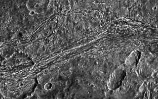 <h1>PIA01612:  A Tumultuous Past for Ganymede's Dark Terrain</h1><div class="PIA01612" lang="en" style="width:615px;text-align:left;margin:auto;background-color:#000;padding:10px;max-height:150px;overflow:auto;"><p>Dark terrain of Nicholson Regio on Jupiter's moon, Ganymede. On the left is a crater that has been torn apart by tectonic forces. A lane of ridges and grooves (probably extensional fault blocks) cuts through the crater and distorts its originally circular shape. Though such deformation is more typical of Ganymede's bright grooved terrain, this image demonstrates that extreme tectonic disruption has occurred in the satellite's dark terrain also. The pair of oblong craters on the right was formed by the impact of a gravitationally bound pair of asteroids or a split comet. The oblong shapes of the craters suggest that the impactors struck the surface at a shallow angle. Toward the top left, an old crater has been partially buried by dark ejecta tossed from another impact about 50 kilometers to the north of this image.</p><p>North is to the top of the picture and the sun illuminates the surface from the right. The image, centered at 14 degrees south latitude and 352 degrees longitude, covers an area approximately 111 by 93 kilometers. The resolution is 180 meters per picture element. The image was taken on April 5, 1997 at 6 hours, 31 minutes, 44 seconds Universal Time at a range of 17,840 kilometers by the Solid State Imaging (SSI) system on NASA's Galileo spacecraft.</p><p>The Jet Propulsion Laboratory, Pasadena, CA manages the Galileo mission for NASA's Office of Space Science, Washington, DC.</p><p>This image and other images and data received from Galileo are posted on the World Wide Web, on the Galileo mission home page at URL <a href="http://solarsystem.nasa.gov/galileo/" target="_blank">http://solarsystem.nasa.gov/galileo/</a>. Background information and educational context for the images can be found at <a href="http://www2.jpl.nasa.gov/galileo/sepo/" target="_blank">http://www.jpl.nasa.gov/galileo/sepo</a>.<br /><br /><a href="http://photojournal.jpl.nasa.gov/catalog/PIA01612" onclick="window.open(this.href); return false;" title="Voir l'image 	 PIA01612:  A Tumultuous Past for Ganymede's Dark Terrain	  sur le site de la NASA">Voir l'image 	 PIA01612:  A Tumultuous Past for Ganymede's Dark Terrain	  sur le site de la NASA.</a></div>