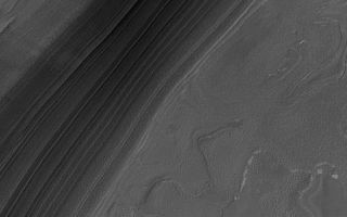 <h1>PIA01934:  Frost-free North Polar Layers in the Good Old Summertime</h1><div class="PIA01934" lang="en" style="width:800px;text-align:left;margin:auto;background-color:#000;padding:10px;max-height:150px;overflow:auto;"><p>17 October 2006<br />The middle portion of the northern summer season is the ideal time of year to capture relatively dust- and haze-free views of martian north polar terrain. This year, much more of the north polar cap has sublimed away than has been evident in previous northern summers going back to 1999, when Mars Global Surveyor (MGS) began the Mapping Phase of the mission. This MGS Mars Orbiter Camera (MOC) image shows a nearly ice-free view of layers exposed by erosion in the north polar region. The light-toned patches are remnants of water ice frost. The layers are generally considered by the Mars scientific community to be record of past depositions of ice and dust. This picture is located near 82.5°N, 118.6°W, and covers an area about 3 km by 10 km (1.9 by 6.2 miles). Sunlight illuminates the scene from the upper left; the image was acquired on 22 September 2006.</p><br /><br /><a href="http://photojournal.jpl.nasa.gov/catalog/PIA01934" onclick="window.open(this.href); return false;" title="Voir l'image 	 PIA01934:  Frost-free North Polar Layers in the Good Old Summertime	  sur le site de la NASA">Voir l'image 	 PIA01934:  Frost-free North Polar Layers in the Good Old Summertime	  sur le site de la NASA.</a></div>