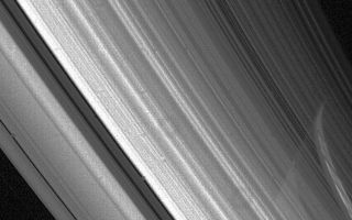 <h1>PIA01962:  High-resolution view of Saturn's rings</h1><div class="PIA01962" lang="en" style="width:750px;text-align:left;margin:auto;background-color:#000;padding:10px;max-height:150px;overflow:auto;">Voyager 2 high-resolution view of Saturn's rings Aug. 23 at a range of 3.3 million kilometers (2 million miles). The planets limb is visible through the C-ring and the inner part of the B-ring. The ring shadows have been obscured by the bright band of light, evident on Saturns surface, that passed through the more transparent Cassini Division. The Cassini Division is the darker gap that extends from the lower center of this image to the upper left; it is about 5,000 km. (3,100 mi.) wide. Many bright and dark ringlets are seen throughout the complex ring system. The Voyager project is managed for NASA by the Jet Propulsion Laboratory, Pasadena, Calif.<br /><br /><a href="http://photojournal.jpl.nasa.gov/catalog/PIA01962" onclick="window.open(this.href); return false;" title="Voir l'image 	 PIA01962:  High-resolution view of Saturn's rings	  sur le site de la NASA">Voir l'image 	 PIA01962:  High-resolution view of Saturn's rings	  sur le site de la NASA.</a></div>