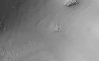<h1>PIA02018:  MOC "Looking Into" Martian Craters</h1><div class="PIA02018" lang="en" style="width:290px;text-align:left;margin:auto;background-color:#000;padding:10px;max-height:150px;overflow:auto;"><p>During the first week of May 1999, the Mars Orbiter Camera (MOC) spent sometime peering into martian impact craters.</p><p>This crater is located in south-central Syria Planum and is about 7.0 kilometers (4.4 miles) across. Illumination is from the upper left.</p><p>If you have ever visited the famous Meteor Crater in northern Arizona, U.S.A., then you are aware of its immense size on a human scale. The Arizona crater, however, is only 1 kilometer across (0.62 miles), whereas this crater is seven times wider.</p><p>This crater was formed by the impact and explosion of a meteorite at some time in the martian past. After the crater formed, it was modified by wind and erosion. The crater shows deposits of sand and dust on the floor and in low areas around their rim, also boulders and other debris that has slid down the inside walls of the crater; and some crater walls show exposures of bedrock.</p><p>Malin Space Science Systems and the California Institute of Technology built the MOC using spare hardware from the Mars Observer mission. MSSS operates the camera from its facilities in San Diego, CA. The Jet Propulsion Laboratory's Mars Surveyor Operations Project operates the Mars Global Surveyor spacecraft with its industrial partner, Lockheed Martin Astronautics, from facilities in Pasadena, CA and Denver, CO.</p><br /><br /><a href="http://photojournal.jpl.nasa.gov/catalog/PIA02018" onclick="window.open(this.href); return false;" title="Voir l'image 	 PIA02018:  MOC "Looking Into" Martian Craters	  sur le site de la NASA">Voir l'image 	 PIA02018:  MOC "Looking Into" Martian Craters	  sur le site de la NASA.</a></div>