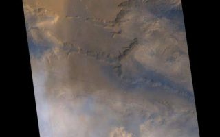 <h1>PIA02045:  May 1999 Dust Storm in Valles Marineris</h1><div class="PIA02045" lang="en" style="width:558px;text-align:left;margin:auto;background-color:#000;padding:10px;max-height:150px;overflow:auto;"><p>Mars Global Surveyor's (MGS) Mars Orbiter Camera (MOC) captured this view of a dust storm within the Ius and Melas Chasms of the Valles Marineris trough system on May 16, 1999.</p><p>The dust storm is seen in the lower 1/3 of the image. It occurs at the junction between eastern Ius Chasma and western Melas Chasma. The apparent motion of the storm is approximately from the south (bottom of image) toward the north. The dust cloud forms a sharp front along its northern margin, which is seen along the north wall of Ius and Melas Chasms--in fact, at the time the image was taken, the dust had advanced up over the north wall of Melas Chasma (upper portion of lower right third of image) and was advancing across the upland that separates this chasm from western Candor Chasma. For a clear-atmosphere view of western Candor and Melas Chasms, see <a href="http://www.msss.com/mars/global_surveyor/camera/images/3_25_99_vmcolor/index.html">"Western Melas and Candor Chasms, Valles Marineris, MOC2-105, 25 March 1999"</a>.</p><p>For scale, note that the large crater south of Hebes Chasma, Perrotin, is about 95 kilometers (59 miles) across. Bluish-white clouds in the image are interpreted to consist of water ice. The pink/red clouds of the dust storm occur closer to the ground, at a lower altitude than the water ice clouds.</p><p>One of the most interesting aspects of this dust storm is that Valles Marineris was observed to have a dust storm at exactly the same time of year, one Martian year ago. During its approach to Mars, MOC obtained a picture of the planet on July 2,1997, just prior to the Mars Pathfinder landing. At the time, it was winter in the southern hemisphere, and dust clouds were observed within Valles Marineris. The picture is seen in <a href="http://www.msss.com/mars/global_surveyor/camera/images/c9/index.html">"Mars Orbiter Camera Views Mars Pathfinder Landing Site,MOC2-1, 3 July 1997"</a>. It will be interesting to see if similar storms occur within the Valles Marineris 1 and 2 Mars years hence. The next times will be in early April 2001 and mid-February 2003.</p><p>Malin Space Science Systems and the California Institute of Technology built the MOC using spare hardware from the Mars Observer mission. MSSS operates the camera from its facilities in San Diego, CA. The Jet Propulsion Laboratory's Mars Surveyor Operations Project operates the Mars Global Surveyor spacecraft with its industrial partner, Lockheed Martin Astronautics, from facilities in Pasadena, CA and Denver, CO.</p><br /><br /><a href="http://photojournal.jpl.nasa.gov/catalog/PIA02045" onclick="window.open(this.href); return false;" title="Voir l'image 	 PIA02045:  May 1999 Dust Storm in Valles Marineris	  sur le site de la NASA">Voir l'image 	 PIA02045:  May 1999 Dust Storm in Valles Marineris	  sur le site de la NASA.</a></div>