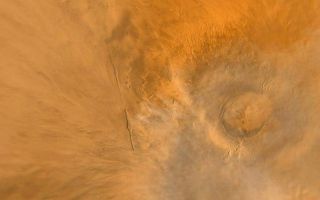 <h1>PIA02337:  Wide Angle View of Arsia Mons Volcano</h1><div class="PIA02337" lang="en" style="width:742px;text-align:left;margin:auto;background-color:#000;padding:10px;max-height:150px;overflow:auto;"><p>Arsia Mons (above) is one of the largest volcanoes known. This shield volcano is part of an aligned trio known as the Tharsis Montes--the others are Pavonis Mons and Ascraeus Mons. Arsia Mons is rivaled only by Olympus Mons in terms of its volume. The summit of Arsia Mons is more than 9 kilometers (5.6 miles) higher than the surrounding plains. The crater--or caldera--at the volcano summit is approximately 110 km (68 mi) across. This view of Arsia Mons was taken by the red and blue wide angle cameras of the Mars Global Surveyor Mars Orbiter Camera (MOC) system. Bright water ice clouds (the whitish/bluish wisps) hang above the volcano--a common sight every martian afternoon in this region. Arsia Mons is located at 120° west longitude and 9° south latitude. Illumination is from the left.<br /><br /><a href="http://photojournal.jpl.nasa.gov/catalog/PIA02337" onclick="window.open(this.href); return false;" title="Voir l'image 	 PIA02337:  Wide Angle View of Arsia Mons Volcano	  sur le site de la NASA">Voir l'image 	 PIA02337:  Wide Angle View of Arsia Mons Volcano	  sur le site de la NASA.</a></div>