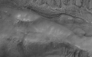 <h1>PIA02919:  Bi-level Gullies</h1><div class="PIA02919" lang="en" style="width:800px;text-align:left;margin:auto;background-color:#000;padding:10px;max-height:150px;overflow:auto;"><p>15 March 2006<br />This Mars Global Surveyor (MGS) Mars Orbiter Camera (MOC) image shows two suites of gullies within a single impact crater in the Terra Cimmeria region. The gullies near the top of the image are located on the northern wall of the crater, while the lower suite resides on a lower bench in the crater's northern wall complex. Gully erosion has cut into the layered rock exposed on the crater wall. Water may have been involved in their formation.</p><p>Location near: 38.2°S, 190.6°W <br />Image width: ~3 km (~1.9 mi) <br />Illumination from: upper left <br />Season: Southern Summer </p><br /><br /><a href="http://photojournal.jpl.nasa.gov/catalog/PIA02919" onclick="window.open(this.href); return false;" title="Voir l'image 	 PIA02919:  Bi-level Gullies	  sur le site de la NASA">Voir l'image 	 PIA02919:  Bi-level Gullies	  sur le site de la NASA.</a></div>