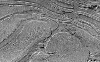 <h1>PIA03210:  Strange Surfaces of Hellas Planitia</h1><div class="PIA03210" lang="en" style="width:640px;text-align:left;margin:auto;background-color:#000;padding:10px;max-height:150px;overflow:auto;"><p>Sometimes Mars Global Surveyor (MGS) Mars Orbiter Camera (MOC) images show things that look very bizarre. Unique among the MOC images is a suite of pictures from northwestern Hellas Planitia, such as the example shown here. The seeming familiarity of many MOC images, such as those showing Earth-like sand dunes or stream-like gullies might give the impression that it is pretty easy to understand what MOC images are telling us about the geology of Mars. Indeed, much of what has been found by MOC is both interpretable and profound--layers recording the planet's early geologic history, evidence for recent groundwater emerging at the surface, dust storms and frost patterns that indicate seasonal change. However, many martian landforms remain unexplained and may require years of study. This picture, acquired in late October 2000, appears to be a jumble of plates or layers exposed at the surface but subsequently covered by a thin mantle to give the scene a uniform brightness. What are these materials? Perhaps time and careful study will tell. The picture is illuminated from the upper left and covers an area 2.9 by 4.1 km (1.8 by 2.5 mi) near 39.7°S, 306.7°W.<br /><br /><a href="http://photojournal.jpl.nasa.gov/catalog/PIA03210" onclick="window.open(this.href); return false;" title="Voir l'image 	 PIA03210:  Strange Surfaces of Hellas Planitia	  sur le site de la NASA">Voir l'image 	 PIA03210:  Strange Surfaces of Hellas Planitia	  sur le site de la NASA.</a></div>