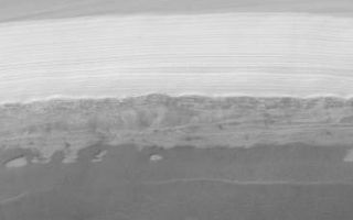 <h1>PIA03468:  MGS MOC Extended Mission View of North Polar Layers</h1><div class="PIA03468" lang="en" style="width:800px;text-align:left;margin:auto;background-color:#000;padding:10px;max-height:150px;overflow:auto;">The north polar cap of Mars is the only place on the surface of the planet that is known to have water. Of course, the water there is frozen. Unfortunately, the martian north polar cap has been a difficult place for the Mars Global Surveyor (MGS) Mars Orbiter Camera (MOC) to view. Each winter, the pole spends approximately 6 months in darkness. Each spring, everything is covered with frost. In summer and through autumn, the cap is often obscured by clouds--sometimes clouds of dust from raging dust storms, and sometimes clouds of water ice crystals. However, a period of excellent viewing conditions occurred early in the MGS Extended Mission (from February through April 2001). This image, taken by MOC in April 2001, shows the layers comprising the north polar cap exposed in an arcuate scarp that occurs at one end of Chasma Boreale. MOC images acquired in 1999 showed that the polar cap has two types of layers: there is a stack of light-toned, nearly uniformly-bedded layers at the top, and a stack of darker-toned beds that form shelves and benches at the bottom. The darker, lower beds are older. Dozens of MOC images were targeted during the clear-atmosphere period in 2001 to test the MOC team's hypotheses about the polar cap layers and these images have helped in documenting the nature of these layers. The lower, dark layers of the polar cap appear to include considerable amounts of sand, while the upper layers lack sand and instead may be a mixture of ice and dust. The lower layers appear to contributes and to the dune fields that surround the polar cap, though no dunes are present in the image shown here. This image is illuminated from the lower right and covers an area 14.5 km (9 mi.) across. The scarp slopes toward the bottom of the scene.<p>Malin Space Science Systems and the California Institute of Technology built the MOC using spare hardware from the Mars Observer mission. MSSS operates the camera from its facilities in San Diego, CA. The Jet Propulsion Laboratory's Mars Surveyor Operations Project operates the Mars Global Surveyor spacecraft with its industrial partner, Lockheed Martin Astronautics, from facilities in Pasadena, CA and Denver, CO.<br /><br /><a href="http://photojournal.jpl.nasa.gov/catalog/PIA03468" onclick="window.open(this.href); return false;" title="Voir l'image 	 PIA03468:  MGS MOC Extended Mission View of North Polar Layers	  sur le site de la NASA">Voir l'image 	 PIA03468:  MGS MOC Extended Mission View of North Polar Layers	  sur le site de la NASA.</a></div>