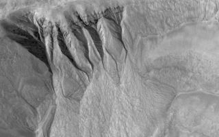 <h1>PIA03585:  South Mid-latitude Gullies</h1><div class="PIA03585" lang="en" style="width:800px;text-align:left;margin:auto;background-color:#000;padding:10px;max-height:150px;overflow:auto;"><p>19 November 2005<br />This Mars Global Surveyor (MGS) Mars Orbiter Camera (MOC) image shows deep gullies cut into the wall of a south mid-latitude crater. Erosion has exposed layers in the upper wall of the crater; it is possible that groundwater seeping through a layer or layers in the wall led to the genesis of the gullies. The banked nature of the gully channels suggests that a liquid was involved.<p>Location near: 35.5°S, 194.8°W <br />Image width: width: ~2 km (~1.2 mi)<br />Illumination from: upper left <br />Season: Southern Spring </p><br /><br /><a href="http://photojournal.jpl.nasa.gov/catalog/PIA03585" onclick="window.open(this.href); return false;" title="Voir l'image 	 PIA03585:  South Mid-latitude Gullies	  sur le site de la NASA">Voir l'image 	 PIA03585:  South Mid-latitude Gullies	  sur le site de la NASA.</a></div>