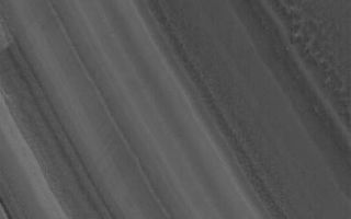 <h1>PIA03666:  North Polar Layers</h1><div class="PIA03666" lang="en" style="width:396px;text-align:left;margin:auto;background-color:#000;padding:10px;max-height:150px;overflow:auto;"><p>13 January 2006<br />This Mars Global Surveyor (MGS) Mars Orbiter Camera (MOC) image shows a slope on which layered materials are exposed by erosion in the north polar region of Mars. Wind streaks are also evident in this summertime scene. The layers that make up the material beneath the ice of the north polar residual cap are typically considered to be a mixture of some amount of dust and ice, but the proportions of these constituents are not known.</p><p>Location near: 82.6°N, 298.1°W <br />Image width: ~3 km (~1.9 mi) <br />Illumination from: lower left <br />Season: Northern Summer </p><br /><br /><a href="http://photojournal.jpl.nasa.gov/catalog/PIA03666" onclick="window.open(this.href); return false;" title="Voir l'image 	 PIA03666:  North Polar Layers	  sur le site de la NASA">Voir l'image 	 PIA03666:  North Polar Layers	  sur le site de la NASA.</a></div>