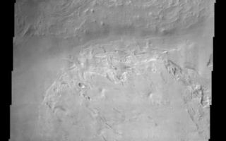 <h1>PIA03849:  Spallanzani Crater</h1><div class="PIA03849" lang="en" style="width:442px;text-align:left;margin:auto;background-color:#000;padding:10px;max-height:150px;overflow:auto;"><a href="/figures/PIA03849a-context.jpg"></a><br>(Released 17 July 2002)<br>The craters on Mars display a variety of interior deposits one of which is shown here. Spallanzani Crater is located far enough south that it probably experiences the seasonal growth and retreat of the south polar cap. During the southern hemisphere winter, CO2 frost condenses out of the atmosphere onto the surface and probably brings with it small amounts of dust and even water ice. It is this sort of depositional process that is thought to have produced the polar layered deposits. The layered deposit in Spallanzani Crater shares some similarities with the polar deposits. Whatever the origin of the layered materials, they likely filled the crater at one time. Note how the interior slope of the northern rim displays layered material of similar if less distinct morphology as the main deposit on the floor. The process that filled the crater with sediment has been replaced by the opposite process. Erosion has taken over, leaving behind spectacular stair-stepped mesas and bizarre, contorted landforms. Unlike the interior crater deposits in the equatorial latitudes, the erosional process has not produced the yardang features that indicate wind erosion. It may be that ice was one of the cementing agents of the sediment and perhaps the sublimation of that ice has left the sediment susceptible to erosion. The details of the deposition and erosion of this interesting deposit remain to be discovered.<br><br /><br /><a href="http://photojournal.jpl.nasa.gov/catalog/PIA03849" onclick="window.open(this.href); return false;" title="Voir l'image 	 PIA03849:  Spallanzani Crater	  sur le site de la NASA">Voir l'image 	 PIA03849:  Spallanzani Crater	  sur le site de la NASA.</a></div>