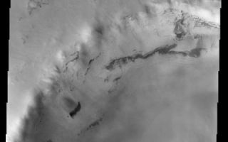<h1>PIA03912:  Frosted Crater</h1><div class="PIA03912" lang="en" style="width:480px;text-align:left;margin:auto;background-color:#000;padding:10px;max-height:150px;overflow:auto;"><a href="/figures/PIA03912a-context.jpg"></a><br>(Released 2 August 2002)<br>This image, located near 70.6 N and 102.95 E, displays a frosted crater in the Martian northern hemisphere. This image was taken during the northern spring as the CO2 ice cap starts to sublimate and recede. Exposures of the underlying surface are prominent around topographic features because of the exposure they provide. Features that are more exposed to the relatively warm air will be sublimated away more quickly. South facing slopes in the northern hemisphere are also exposed to more sunlight, which also helps to sublimate the frost. This is why the north rim of the large crater has more exposures of the relatively dark underlying material than the southern (north facing) wall. There are also what appears to be small slides of material on the crater walls. This may be sand that becomes unstable as the frost cover thins.<br><br /><br /><a href="http://photojournal.jpl.nasa.gov/catalog/PIA03912" onclick="window.open(this.href); return false;" title="Voir l'image 	 PIA03912:  Frosted Crater	  sur le site de la NASA">Voir l'image 	 PIA03912:  Frosted Crater	  sur le site de la NASA.</a></div>