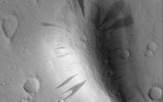 <h1>PIA03920:  Slope-Streaked Knob</h1><div class="PIA03920" lang="en" style="width:672px;text-align:left;margin:auto;background-color:#000;padding:10px;max-height:150px;overflow:auto;"><p>28 May 2005<br />This Mars Global Surveyor (MGS) Mars Orbiter Camera (MOC) image shows dark slope streaks coming down the slopes of a knob in western Amazonis Planitia. All of the surfaces in this image are mantled by dust. On the slopes, mass movement of dry dust has created the streaks.</p><p>Location near: 19.6°N, 166.1°W<br />Image width: ~3 km (~1.9 mi <br />Illumination from: lower left <br />Season: Northern Autumn <br /></p><br /><br /><a href="http://photojournal.jpl.nasa.gov/catalog/PIA03920" onclick="window.open(this.href); return false;" title="Voir l'image 	 PIA03920:  Slope-Streaked Knob	  sur le site de la NASA">Voir l'image 	 PIA03920:  Slope-Streaked Knob	  sur le site de la NASA.</a></div>