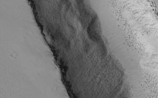 <h1>PIA04113:  Bouldery Trough</h1><div class="PIA04113" lang="en" style="width:593px;text-align:left;margin:auto;background-color:#000;padding:10px;max-height:150px;overflow:auto;"><p>22 July 2005<br />This Mars Global Surveyor (MGS) Mars Orbiter Camera (MOC) image shows a 1.5 meters per pixel (~5 ft/pixel) view of the interior of a trough, formed by faulting, on the lower southwest flank of Biblis Patera, a volcano in the Tharsis region of Mars. Boulders tend to be most common in volcanic regions, attesting to the hardness of the volcanic rock. In this case, the boulders and surrounding terrain have been largely mantled with dust.</p><p>Location near: 1.3°N, 124.9°W <br />Image width: width: ~3 km (~1.9 mi) <br />Illumination from: lower left <br />Season: Northern Autumn</p><br /><br /><a href="http://photojournal.jpl.nasa.gov/catalog/PIA04113" onclick="window.open(this.href); return false;" title="Voir l'image 	 PIA04113:  Bouldery Trough	  sur le site de la NASA">Voir l'image 	 PIA04113:  Bouldery Trough	  sur le site de la NASA.</a></div>