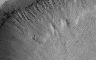 <h1>PIA04116:  Martian Gullies</h1><div class="PIA04116" lang="en" style="width:702px;text-align:left;margin:auto;background-color:#000;padding:10px;max-height:150px;overflow:auto;"><p>25 July 2005<br />This Mars Global Surveyor (MGS) Mars Orbiter Camera (MOC) image shows a gullied crater wall in the Terra Sirenum region of Mars. The fluids that formed the gully channels and deposited debris in aprons at the base of the crater wall may have percolated through layers in the layered bedrock exposed in the crater wall. As fluid seeped out of the ground, it undermined overlying layers of rock, and caused the formation of several compex alcoves, higher in the crater wall. The formation of alcoves requires the undermining and collapse of layered material at a point where the channel begins; this is a key observation supporting the hypothesis that martian gullies require groundwater, not snowmelt or other exotic processes or fluids, to form. </p><p>Location near: 37.3°S, 153.2°W <br />Image width: width: ~3 km (~1.9 mi) <br />Illumination from: upper left <br />Season: Southern Spring </p><br /><br /><a href="http://photojournal.jpl.nasa.gov/catalog/PIA04116" onclick="window.open(this.href); return false;" title="Voir l'image 	 PIA04116:  Martian Gullies	  sur le site de la NASA">Voir l'image 	 PIA04116:  Martian Gullies	  sur le site de la NASA.</a></div>