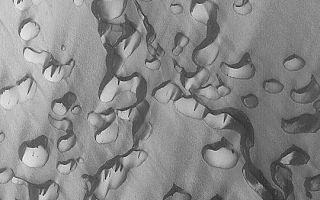 <h1>PIA04509:  Chasma Boreale Dunes</h1><div class="PIA04509" lang="en" style="width:540px;text-align:left;margin:auto;background-color:#000;padding:10px;max-height:150px;overflow:auto;">MGS MOC Release No. MOC2-354, 8 May 2003<p>In this Mars Global Surveyor (MGS) Mars Orbiter Camera (MOC) image, wind has streaked a field of defrosting sand dunes in Chasma Boreale in the martian north polar region. Dune slip faces--the steep slope formed by avalanching sand on each dune--and the dark streaks indicate that wind transports sediment from the lower left toward the upper right. The picture covers an area about 3 km (1.9 mi) wide near 84.6°N, 358.5°W. Sunlight illuminates the scene from the lower left.<p><br /><br /><a href="http://photojournal.jpl.nasa.gov/catalog/PIA04509" onclick="window.open(this.href); return false;" title="Voir l'image 	 PIA04509:  Chasma Boreale Dunes	  sur le site de la NASA">Voir l'image 	 PIA04509:  Chasma Boreale Dunes	  sur le site de la NASA.</a></div>
