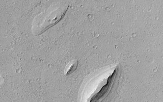 <h1>PIA04571:  Layered Yardangs in Henry Crater</h1><div class="PIA04571" lang="en" style="width:540px;text-align:left;margin:auto;background-color:#000;padding:10px;max-height:150px;overflow:auto;">MGS MOC Release No. MOC2-389, 12 June 2003<p>This Mars Global Surveyor (MGS) Mars Orbiter Camera (MOC) image shows wind-sculpted remnants of layered sedimentary rock that once completely covered the northwestern floor of Henry Crater, an ancient impact basin located at 11.7°N, 336.4°W. These landforms, shaped somewhat like inverted boat hulls, are "textbook examples" of a wind erosion form known as a yardang. The image covers an area 2.3 km (1.4 mi) wide; sunlight illuminates the scene from the left.<p><br /><br /><a href="http://photojournal.jpl.nasa.gov/catalog/PIA04571" onclick="window.open(this.href); return false;" title="Voir l'image 	 PIA04571:  Layered Yardangs in Henry Crater	  sur le site de la NASA">Voir l'image 	 PIA04571:  Layered Yardangs in Henry Crater	  sur le site de la NASA.</a></div>