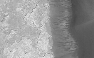 <h1>PIA04610:  Kaiser Dune Avalanches</h1><div class="PIA04610" lang="en" style="width:540px;text-align:left;margin:auto;background-color:#000;padding:10px;max-height:150px;overflow:auto;">MGS MOC Release No. MOC2-410, 3 July 2003<p>Mars Global Surveyor's (MGS) Mars Orbiter Camera (MOC) has obtained thousands of images of martian sand dunes since it began observing the planet from orbit in 1997. Many of the dunes appear to be inactive in the modern environment, but appear to be quite young, otherwise (they do not have any small meteor impact craters on them, they often have sharp edges and brinks--all attributes of modern, active dunes). In some dune fields, as in Herschel Basin in Terra Cimmeria, the dunes are grooved (e.g., see <a href="http://www.msss.com/mars_images/moc/2003/04/19/">Mars Picture of the Day for April 19, 2003</a>), indicating that they have been cemented and then eroded by wind. In the Noachis Terra region of Mars, many dune fields also appear to have been cemented. The evidence in this case comes from the deep scars formed on the slip face slopes by avalanches of sand. This MOC image shows more than a dozen examples a dune in eastern Kaiser Crater near 47.1°S, 340.0°W. If the dunes were not cemented--that is, if the sand was loose--then the avalanches would not leave steep-sided chutes on the slip face slopes. The implication that many martian dunes are cemented and inactive in the modern martian environment, but were active sometime in the not-too-distant past, suggests that the climate of Mars may have changed in recent times. This picture was obtained in June 2003; it is illuminated from the upper left. North is toward the upper right; the area shown here is about 3 km (1.9 mi) wide.<p><br /><br /><a href="http://photojournal.jpl.nasa.gov/catalog/PIA04610" onclick="window.open(this.href); return false;" title="Voir l'image 	 PIA04610:  Kaiser Dune Avalanches	  sur le site de la NASA">Voir l'image 	 PIA04610:  Kaiser Dune Avalanches	  sur le site de la NASA.</a></div>