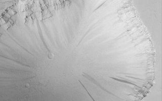 <h1>PIA04636:  Tractus Fossae Collapse Pit</h1><div class="PIA04636" lang="en" style="width:540px;text-align:left;margin:auto;background-color:#000;padding:10px;max-height:150px;overflow:auto;">MGS MOC Release No. MOC2-419, 12 July 2003<p>Extensional faulting, wherein some fraction of the martian crust is pulled apart and faults are formed where the bedrock breaks, has also led to formation of collapse pits in the Tractus Fossae region. This Mars Global Surveyor (MGS) Mars Orbiter Camera (MOC) image shows one such pit and the layered bedrock exposed in its walls. Dark streaks on the slopes of the pit result from avalanches of dry, fine-grained debris (probably dust, as these streaks are only found in the dust-mantled regions of Mars). This pit is located near 23.5°N, 103.8°W. Sunlight illuminates the scene from the lower left.<p><br /><br /><a href="http://photojournal.jpl.nasa.gov/catalog/PIA04636" onclick="window.open(this.href); return false;" title="Voir l'image 	 PIA04636:  Tractus Fossae Collapse Pit	  sur le site de la NASA">Voir l'image 	 PIA04636:  Tractus Fossae Collapse Pit	  sur le site de la NASA.</a></div>