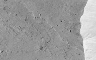 <h1>PIA04689:  Top of Olympus Mons</h1><div class="PIA04689" lang="en" style="width:800px;text-align:left;margin:auto;background-color:#000;padding:10px;max-height:150px;overflow:auto;">MGS MOC Release No. MOC2-455, 17 August 2003<p />Olympus Mons is considered to be the largest and tallest volcano in the Solar System. This Mars Global Surveyor (MGS) Mars Orbiter Camera (MOC) picture shows the western summit region of Olympus Mons. This area is at an elevation just over 20 km (12 mi) above the 0 km martian datum. The bright feature on the right (east) side of the image is the uppermost wall of the caldera (collapse pit) at the top of the volcano. This image shows a lava flow that was cut by the pit walls when the caldera collapse occurred. Below (south of) the lava flow is a narrow channel formed by lava at some time in the distant past. This view of the summit region of Olympus Mons is located near 10.6°N, 134.0°W. The area shown is about 7.9 km (4.9 mi) across. Sunlight illuminates the scene from the right.<br /><br /><a href="http://photojournal.jpl.nasa.gov/catalog/PIA04689" onclick="window.open(this.href); return false;" title="Voir l'image 	 PIA04689:  Top of Olympus Mons	  sur le site de la NASA">Voir l'image 	 PIA04689:  Top of Olympus Mons	  sur le site de la NASA.</a></div>