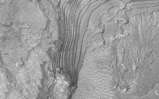 <h1>PIA04721:  Ancient Sedimentary Rocks</h1><div class="PIA04721" lang="en" style="width:799px;text-align:left;margin:auto;background-color:#000;padding:10px;max-height:150px;overflow:auto;">MGS MOC Release No. MOC2-469, 31 August 2003<p />The terraced area in this Mars Global Surveyor (MGS) Mars Orbiter Camera (MOC) image is an outcropping of ancient, sedimentary rock. It occurs in a crater in western Arabia Terra near 10.8°N, 4.5°W. Sedimentary rocks provide a record of past environments on Mars. Field work will likely be required to begin to get a good understanding of the nature of the record these rocks contain. Their generally uniform thickness and repeated character suggests that deposition of fine sediment in this crater was episodic, if not cyclic. These rocks might be indicators of an ancient lake, or they might have been deposited from grains settling out of an earlier, thicker, martian atmosphere. This image covers an area 3 km (1.9 mi) across and is illuminated from the lower left.<br /><br /><a href="http://photojournal.jpl.nasa.gov/catalog/PIA04721" onclick="window.open(this.href); return false;" title="Voir l'image 	 PIA04721:  Ancient Sedimentary Rocks	  sur le site de la NASA">Voir l'image 	 PIA04721:  Ancient Sedimentary Rocks	  sur le site de la NASA.</a></div>