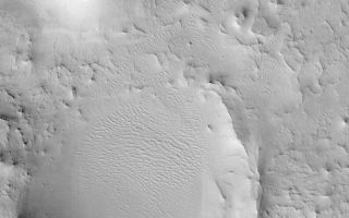 <h1>PIA04725:  Eroded Cratered Highlands</h1><div class="PIA04725" lang="en" style="width:800px;text-align:left;margin:auto;background-color:#000;padding:10px;max-height:150px;overflow:auto;">MGS MOC Release No. MOC2-472, 3 September 2003<p />This August 2003 Mars Global Surveyor (MGS) Mars Orbiter Camera (MOC) picture shows the remains of two former meteor impact craters in northeastern Arabia Terra. The circular mesa toward the northeast (upper left) corner of the image was once a crater that became filled with material. Later, erosion stripped away the surrounding terrain, but left the filled crater behind as a mesa. The larger circular feature in this image is the eroded remains of another meteor crater; its rims and ejecta have been eroded away, and its north/northwest (left/upper left) rim has been completely removed. The processes that have eroded terrain in northeastern Arabia are unknown, but probably, at least, involved deflation by wind. This picture covers an area 3 km (1.9 mi) across and is located near 26.9°N, 301.6°W. Sunlight illuminates the scene from the lower left.<br /><br /><a href="http://photojournal.jpl.nasa.gov/catalog/PIA04725" onclick="window.open(this.href); return false;" title="Voir l'image 	 PIA04725:  Eroded Cratered Highlands	  sur le site de la NASA">Voir l'image 	 PIA04725:  Eroded Cratered Highlands	  sur le site de la NASA.</a></div>