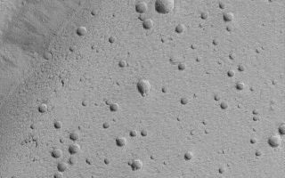 <h1>PIA04755:  Ceraunius Caldera Floor</h1><div class="PIA04755" lang="en" style="width:640px;text-align:left;margin:auto;background-color:#000;padding:10px;max-height:150px;overflow:auto;">MGS MOC Release No. MOC2-489, 20 September 2003<p />This Mars Global Surveyor (MGS) Mars Orbiter Camera (MOC) picture shows the pitted floor of the caldera of the martian volcano, Ceraunius Tholus. A caldera is a large collapse pit at the summit of a volcano. For reference, a wide angle MOC view of Ceraunius Tholus was presented on 18 April 2002, <a href="/catalog/PIA03750">"Volcanoes Ceraunius Tholus and Uranius Tholus."</a> Today's picture shows a close-up view of the volcano's caldera floor. The floor exhibits many pits and holes, but it is uncertain whether these were formed by meteor impact, volcanic eruptions, or collapse. Most of them do not have raised rims and ejecta-two features characteristic of meteor impact craters (although a few shown here have raised rims); and none have lava flows or volcanic cones associated with them-characteristics of volcanic eruption. Thus, these pits might have formed by collapse, although it is more likely that they were formed by meteor impact, but the ejecta and rims have been buried by dust or eroded away. This picture is located near 24.3°N, 97.4°W, and covers an area 3 km (1.9 mi) across. Sunlight illuminates the scene from the lower left.<br /><br /><a href="http://photojournal.jpl.nasa.gov/catalog/PIA04755" onclick="window.open(this.href); return false;" title="Voir l'image 	 PIA04755:  Ceraunius Caldera Floor	  sur le site de la NASA">Voir l'image 	 PIA04755:  Ceraunius Caldera Floor	  sur le site de la NASA.</a></div>