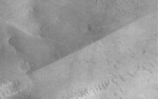 <h1>PIA04792:  Albedo Boundary</h1><div class="PIA04792" lang="en" style="width:673px;text-align:left;margin:auto;background-color:#000;padding:10px;max-height:150px;overflow:auto;">MGS MOC Release No. MOC2-510, 11 October 2003<p />The sharp, nearly straight line that runs diagonally across the center of this April 2003 Mars Global Surveyor (MGS) Mars Orbiter Camera (MOC) image is an albedo boundary. Albedois a term that refers to reflectance of sunlight. A surface with a low albedo is one that appears dark because it reflects less light than a high albedo (bright) surface. On Mars, albedo boundaries occur between two materials of differing texture, particle size, or composition, or some combination of these three factors. The boundary shown here is remarkable because it is so sharp and straight. This is caused by wind. Most likely, the entire surface was once covered with the lower-albedo (darker) material that is now seen in the upper half of the image. At some later time, wind stripped away this darker material from the surfaces in the lower half of the image. The difference in albedo here might be related to composition, and possibly particle size. This picture is located near the southwest rim of Schiaparelli Basin at 5.5°S, 345.9°W. The picture covers an area 3 km (1.9 mi) wide and is illuminated by sunlight from the left.<br /><br /><a href="http://photojournal.jpl.nasa.gov/catalog/PIA04792" onclick="window.open(this.href); return false;" title="Voir l'image 	 PIA04792:  Albedo Boundary	  sur le site de la NASA">Voir l'image 	 PIA04792:  Albedo Boundary	  sur le site de la NASA.</a></div>