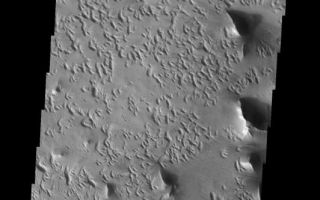 <h1>PIA04946:  Strange Erosional Features</h1><div class="PIA04946" lang="en" style="width:532px;text-align:left;margin:auto;background-color:#000;padding:10px;max-height:150px;overflow:auto;"><p /><a href="/figures/PIA04946_context.jpg"></a><br /><p />Released 19 December 2003<p />The strange erosional pattern seen in this THEMIS visible image differs greatly from the surrounding terrain of Lycus Sulchi (see context image). The crescent-shaped erosional pits trend in the southwest-northeast direction, indicating a dominant wind direction from the southwest. Why these pits eroded in the shapes that they did, however, is a mystery.<p />Image information: VIS instrument. Latitude 18.6, Longitude 214.6 East (145.4 West). 19 meter/pixel resolution.<p />Note: this THEMIS visual image has not been radiometrically nor geometrically calibrated for this preliminary release. An empirical correction has been performed to remove instrumental effects. A linear shift has been applied in the cross-track and down-track direction to approximate spacecraft and planetary motion. Fully calibrated and geometrically projected images will be released through the Planetary Data System in accordance with Project policies at a later time.<p />NASA's Jet Propulsion Laboratory manages the 2001 Mars Odyssey mission for NASA's Office of Space Science, Washington, D.C. The Thermal Emission Imaging System (THEMIS) was developed by Arizona State University, Tempe, in collaboration with Raytheon Santa Barbara Remote Sensing. The THEMIS investigation is led by Dr. Philip Christensen at Arizona State University. Lockheed Martin Astronautics, Denver, is the prime contractor for the Odyssey project, and developed and built the orbiter. Mission operations are conducted jointly from Lockheed Martin and from JPL, a division of the California Institute of Technology in Pasadena.<br /><br /><a href="http://photojournal.jpl.nasa.gov/catalog/PIA04946" onclick="window.open(this.href); return false;" title="Voir l'image 	 PIA04946:  Strange Erosional Features	  sur le site de la NASA">Voir l'image 	 PIA04946:  Strange Erosional Features	  sur le site de la NASA.</a></div>