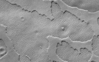<h1>PIA04972:  South Polar Mesas</h1><div class="PIA04972" lang="en" style="width:512px;text-align:left;margin:auto;background-color:#000;padding:10px;max-height:150px;overflow:auto;">MGS MOC Release No. MOC2-573, 13 December 2003<p />This Mars Global Surveyor (MGS) Mars Orbiter Camera (MOC) image shows mesas--the eroded remnants of a former layer or group of layers--in the south polar region of Mars. The circular feature at the top of the image is an old meteor impact crater that has been somewhat covered by younger materials; a remnant of the layer that comprises the mesas is also found on the floor of this crater. The image is located near 79.3°S, 299.0°W, and covers an area 3 km (1.9 mi) wide. Sunlight illuminates this scene from the upper left.<br /><br /><a href="http://photojournal.jpl.nasa.gov/catalog/PIA04972" onclick="window.open(this.href); return false;" title="Voir l'image 	 PIA04972:  South Polar Mesas	  sur le site de la NASA">Voir l'image 	 PIA04972:  South Polar Mesas	  sur le site de la NASA.</a></div>