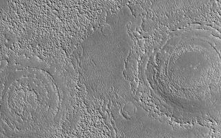 <h1>PIA04976:  Buried Mid-Latitude Craters</h1><div class="PIA04976" lang="en" style="width:668px;text-align:left;margin:auto;background-color:#000;padding:10px;max-height:150px;overflow:auto;">MGS MOC Release No. MOC2-577, 17 December 2003<p />This September 2003 Mars Global Surveyor (MGS) Mars Orbiter Camera (MOC) picture shows six circular features, three of which exhibit concentric, or "bullseye," patterns within them. Each circular feature is the remains of a partly-buried, partly-eroded, and partly-filled meteor impact crater. These occur in northeastern Arabia Terra. Areas such as this, located near the middle latitudes of Mars, commonly have a "scabby" or roughened appearance. The cause of this "terrain roughening" texture is unknown, although some scientists have speculated that it might result from the erosion and removal (by way of sublimation) of ground ice. This idea remains highly speculative. These features are located near 28.4°N, 317.5°W. The image covers an area 3 km (1.9 mi) wide; sunlight illuminates the scene from the lower left.<br /><br /><a href="http://photojournal.jpl.nasa.gov/catalog/PIA04976" onclick="window.open(this.href); return false;" title="Voir l'image 	 PIA04976:  Buried Mid-Latitude Craters	  sur le site de la NASA">Voir l'image 	 PIA04976:  Buried Mid-Latitude Craters	  sur le site de la NASA.</a></div>