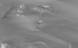 <h1>PIA05014:  Windblown Sand in West Candor</h1><div class="PIA05014" lang="en" style="width:800px;text-align:left;margin:auto;background-color:#000;padding:10px;max-height:150px;overflow:auto;">23 December 2003<p />West Candor Chasma, a part of the vast Valles Marineris trough system, is known for its layered sedimentary rock outcrops. It is less known for dark fields of windblown sand, but that is what occurs in the north-central part of the chasm. This Mars Global Surveyor (MGS) Mars Orbiter Camera (MOC) image, obtained in December 2003, shows the interplay of dark, wind-blown sand with buttes and mesas of layered rock in west Candor Chasma. Dark streamers of sand point toward the east/southeast (right/lower right), indicating that dominant winds blow from the west. This picture is located near 5.2°S, 75.7°W, and covers an area 3 km (1.9 mi) wide. Sunlight illuminates the scene from the lower left.<br /><br /><a href="http://photojournal.jpl.nasa.gov/catalog/PIA05014" onclick="window.open(this.href); return false;" title="Voir l'image 	 PIA05014:  Windblown Sand in West Candor	  sur le site de la NASA">Voir l'image 	 PIA05014:  Windblown Sand in West Candor	  sur le site de la NASA.</a></div>