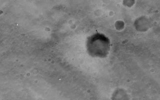 <h1>PIA05248:  MGS MOC Image of Mars Exploration Rover, Spirit, on Mars</h1><div class="PIA05248" lang="en" style="width:800px;text-align:left;margin:auto;background-color:#000;padding:10px;max-height:150px;overflow:auto;"><a href="/figures/PIA05248_label.jpg"></a><br />Click on image for larger view  23 January 2004 <br /> The Mars Global Surveyor (MGS) Mars Orbiter Camera (MOC), operating in martian orbit since September 1997, acquired an image of the Mars Exploration Rover (MER-A), Spirit, on 19 January 2004. The Spirit/Columbia Memorial Station is clearly seen as a bright feature in the image, as are the parachute and backshell from which Spirit was detached during the landing on 4 January 2004 (see inset for annotation). Also evident is a dark scar on the rim of a crater to the northeast of the lander; this dark marking was not present prior to landing, and is believed to have been caused by the impact of Spirit's heatshield. The lander is white because the data received from Mars were saturated at this location--that is, the lander was so much brighter than the surrounding terrain that the camera saw it as a white object.<p />The image shown here is located in Gusev Crater near 14.7°S, 184.6°W. North is up and sunlight illuminates each image from the left. The MOC image was acquired near 2 p.m. local time on Mars. The lander appears white because the DNs (data numbers) received from Mars for the lander were 255--the maximum possible (i.e., the lander was saturated). The values were saturated because of the high sun elevation angle and the fact that the lander and parachute are covered with highly reflective, light-toned materials (as seen in the <a href="/catalog/PIA05117">lander portrait</a> released on 21 January 2004).<br /><br /><a href="http://photojournal.jpl.nasa.gov/catalog/PIA05248" onclick="window.open(this.href); return false;" title="Voir l'image 	 PIA05248:  MGS MOC Image of Mars Exploration Rover, Spirit, on Mars	  sur le site de la NASA">Voir l'image 	 PIA05248:  MGS MOC Image of Mars Exploration Rover, Spirit, on Mars	  sur le site de la NASA.</a></div>
