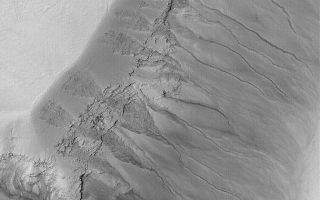 <h1>PIA05444:  Gullied Martian Slope</h1><div class="PIA05444" lang="en" style="width:672px;text-align:left;margin:auto;background-color:#000;padding:10px;max-height:150px;overflow:auto;">25 February 2004 <br /> Gullies cut material that mantles the slopes of a deep pit within a crater in Noachis Terra near 50.1°S, 356.4°W in this Mars Global Surveyor (MGS) Mars Orbiter Camera (MOC) image. Gully channels seem to originate at layer outcrops in the upper walls of the pit. These may have formed by downslope movement of liquid water mixed with debris in the geologically recent martian past. Similar gullies are found throughout much of the martian middle and high latitudes. Sunlight illuminates the scene from the upper left; the picture covers an area 3 km (1.9 mi) wide.<br /><br /><a href="http://photojournal.jpl.nasa.gov/catalog/PIA05444" onclick="window.open(this.href); return false;" title="Voir l'image 	 PIA05444:  Gullied Martian Slope	  sur le site de la NASA">Voir l'image 	 PIA05444:  Gullied Martian Slope	  sur le site de la NASA.</a></div>