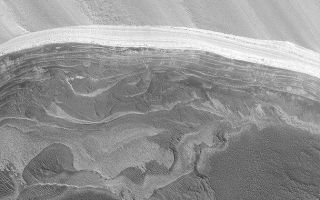 <h1>PIA05530:  North Polar Scarp</h1><div class="PIA05530" lang="en" style="width:672px;text-align:left;margin:auto;background-color:#000;padding:10px;max-height:150px;overflow:auto;">3 March 2004 <br />The north polar cap of Mars overlies a series of layered materials. The upper-most layers are light-toned and may include ice and perhaps dust. The lower layers may be less icy and contain some amount of dark sand. This Mars Global Surveyor (MGS) Mars Orbiter Camera (MOC) image shows an exposure of north polar layers located near 83.9°N, 237.9°W. This view covers an area 3 km (1.9 mi) wide and is illuminated by sunlight from the lower left.<br /><br /><a href="http://photojournal.jpl.nasa.gov/catalog/PIA05530" onclick="window.open(this.href); return false;" title="Voir l'image 	 PIA05530:  North Polar Scarp	  sur le site de la NASA">Voir l'image 	 PIA05530:  North Polar Scarp	  sur le site de la NASA.</a></div>