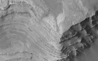 <h1>PIA05641:  Terby's Layered Rocks</h1><div class="PIA05641" lang="en" style="width:800px;text-align:left;margin:auto;background-color:#000;padding:10px;max-height:150px;overflow:auto;">14 March 2004<br />Layered rock outcrops are common all across Mars, and the Mars rover, Opportunity, has recently investigated some layered rocks in Meridiani Planum. This Mars Global Surveyor (MGS) Mars Orbiter Camera (MOC) image shows layered sedimentary rocks in northern Terby Crater, located just north of the giant Hellas Basin near 27.5°S, 285.8°W. Hundreds of layers are exposed in a deposit several kilometers thick within Terby. A history of events that shaped the northern Hellas region is recorded in these rocks, just waiting for a person or robot to investigate. The picture covers an area 3 km (1.9 mi) across. Sunlight illuminates the scene from the left.<br /><br /><a href="http://photojournal.jpl.nasa.gov/catalog/PIA05641" onclick="window.open(this.href); return false;" title="Voir l'image 	 PIA05641:  Terby's Layered Rocks	  sur le site de la NASA">Voir l'image 	 PIA05641:  Terby's Layered Rocks	  sur le site de la NASA.</a></div>