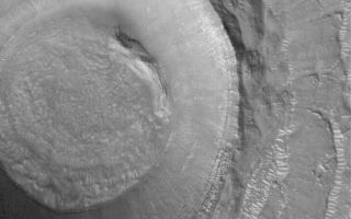 <h1>PIA05642:  Crater in Elysium Planitia</h1><div class="PIA05642" lang="en" style="width:405px;text-align:left;margin:auto;background-color:#000;padding:10px;max-height:150px;overflow:auto;">15 March 2004<br />This Mars Global Surveyor (MGS) Mars Orbiter Camera (MOC) image shows an impact crater in northern Elysium Planitia near 31.3°N, 236.8°W. Layered rock is exposed in the upper crater walls. Light-toned ripples or small dunes can be seen in the crater, on its ejecta blanket, and on the surrounding plains. This February 2004 picture covers an area about 3 km (1.9 mi) across. Sunlight illuminates the scene from the lower left.<br /><br /><a href="http://photojournal.jpl.nasa.gov/catalog/PIA05642" onclick="window.open(this.href); return false;" title="Voir l'image 	 PIA05642:  Crater in Elysium Planitia	  sur le site de la NASA">Voir l'image 	 PIA05642:  Crater in Elysium Planitia	  sur le site de la NASA.</a></div>