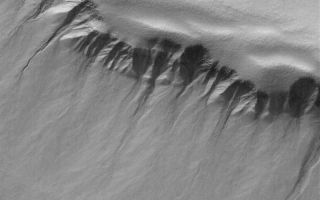 <h1>PIA05644:  South Polar Pit Gullies</h1><div class="PIA05644" lang="en" style="width:800px;text-align:left;margin:auto;background-color:#000;padding:10px;max-height:150px;overflow:auto;">22 March 2004<br />This Mars Global Surveyor (MGS) Mars Orbiter Camera (MOC) image shows gullies and slopes in the walls of a deep pit in the south polar region. The full-resolution (1.5 m/pixel; 5 ft./pixel) image is located near 71.1°S, 358.8°W, and covers an area about 3 km (1.9 mi) across. Sunlight illuminates the scene from the lower left.<br /><br /><a href="http://photojournal.jpl.nasa.gov/catalog/PIA05644" onclick="window.open(this.href); return false;" title="Voir l'image 	 PIA05644:  South Polar Pit Gullies	  sur le site de la NASA">Voir l'image 	 PIA05644:  South Polar Pit Gullies	  sur le site de la NASA.</a></div>