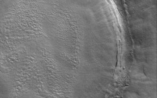 <h1>PIA05697:  Crater in Utopia</h1><div class="PIA05697" lang="en" style="width:532px;text-align:left;margin:auto;background-color:#000;padding:10px;max-height:150px;overflow:auto;">23 March 2004<br />Craters of the martian northern plains tend to be somewhat shallow because material has filled them in. Their ejecta blankets, too, are often covered by younger materials. This Mars Global Surveyor (MGS) Mars Orbiter Camera (MOC) image shows an example--a crater in Utopia Planitia near 43.7°N, 227.3°W. Erosion has roughened some of the surfaces of the material that filled the crater and covered its ejecta deposit. The picture covers an area about 3 km (1.9 mi) across. Sunlight illuminates the scene from the lower left.<br /><br /><a href="http://photojournal.jpl.nasa.gov/catalog/PIA05697" onclick="window.open(this.href); return false;" title="Voir l'image 	 PIA05697:  Crater in Utopia	  sur le site de la NASA">Voir l'image 	 PIA05697:  Crater in Utopia	  sur le site de la NASA.</a></div>