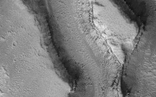<h1>PIA06293:  Features in Granicus Valles</h1><div class="PIA06293" lang="en" style="width:627px;text-align:left;margin:auto;background-color:#000;padding:10px;max-height:150px;overflow:auto;"><p>3 June 2004<br />This Mars Global Surveyor (MGS) Mars Orbiter Camera (MOC) image shows a high resolution view (nearly 1.8 meters; 6 feet per pixel) of landforms in the Granicus Valles region, west of the Elysium volcanoes. Layered rock and some large, dark boulders are among the features observed. The image is located near 27.4°N, 224.8°W, and covers an area only 1.1 km (0.7 mi) across. The scene is illuminated by sunlight from the lower left.</p><br /><br /><a href="http://photojournal.jpl.nasa.gov/catalog/PIA06293" onclick="window.open(this.href); return false;" title="Voir l'image 	 PIA06293:  Features in Granicus Valles	  sur le site de la NASA">Voir l'image 	 PIA06293:  Features in Granicus Valles	  sur le site de la NASA.</a></div>