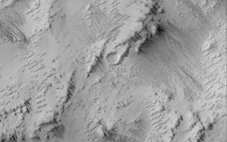 <h1>PIA06325:  Exposing Memnonia Terrain</h1><div class="PIA06325" lang="en" style="width:800px;text-align:left;margin:auto;background-color:#000;padding:10px;max-height:150px;overflow:auto;"><p>21 June 2004<br />This Mars Global Surveyor (MGS) Mars Orbiter Camera (MOC) image shows the results of a process that is underway in the Memnonia uplands near 12.9°S, 152.7°W, to strip away one layer of material and reveal a formerly-buried landscape from beneath. All of the area shown here was once covered by a material that has been eroded by wind to form the sharp-crested, nearly-parallel ridges that run diagonally from the upper left toward lower right in this image. These ridges are a classic wind erosion form, known as a yardang. The image covers an area about 3 km (1.9 mi) wide and is illuminated by sunlight from the left/upper left.</p><br /><br /><a href="http://photojournal.jpl.nasa.gov/catalog/PIA06325" onclick="window.open(this.href); return false;" title="Voir l'image 	 PIA06325:  Exposing Memnonia Terrain	  sur le site de la NASA">Voir l'image 	 PIA06325:  Exposing Memnonia Terrain	  sur le site de la NASA.</a></div>