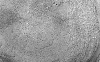 <h1>PIA06368:  Concentric Crater Floor</h1><div class="PIA06368" lang="en" style="width:374px;text-align:left;margin:auto;background-color:#000;padding:10px;max-height:150px;overflow:auto;"><p>8 July 2004<br />This Mars Global Surveyor (MGS) Mars Orbiter Camera (MOC) image shows the interior of a typical crater in northern Acidalia Planitia. The floor is covered by material that forms an almost concentric pattern. In this case, the semi-concentric rings might be an expression of eroded layered material, although this interpretation is uncertain. The crater is located near 44.0°N, 27.7°W, and covers an area about 3 km (1.9 mi) wide. Sunlight illuminates the scene from the lower left.</p><br /><br /><a href="http://photojournal.jpl.nasa.gov/catalog/PIA06368" onclick="window.open(this.href); return false;" title="Voir l'image 	 PIA06368:  Concentric Crater Floor	  sur le site de la NASA">Voir l'image 	 PIA06368:  Concentric Crater Floor	  sur le site de la NASA.</a></div>