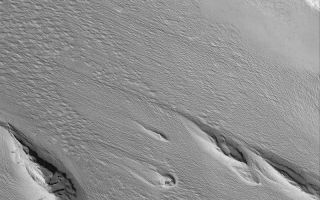 <h1>PIA06385:  Medusae Sulci Yardangs</h1><div class="PIA06385" lang="en" style="width:800px;text-align:left;margin:auto;background-color:#000;padding:10px;max-height:150px;overflow:auto;"><p>13 July 2004<br />Erosive winds have removed large volumes of material in this Mars Global Surveyor (MGS) Mars Orbiter Camera (MOC) image to form yardang ridges. The most classic yardang shape is that of the inverted boat hull; each of these streamlined hills provides a near-textbook example. The landforms are found in the Medusae Sulci region near 5.7°S, 159.8°W. The image covers an area about 3 km (1.9 mi) wide, and is illuminated by sunlight from the lower left.</p><br /><br /><a href="http://photojournal.jpl.nasa.gov/catalog/PIA06385" onclick="window.open(this.href); return false;" title="Voir l'image 	 PIA06385:  Medusae Sulci Yardangs	  sur le site de la NASA">Voir l'image 	 PIA06385:  Medusae Sulci Yardangs	  sur le site de la NASA.</a></div>