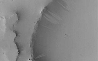 <h1>PIA06699:  Light and Dark Slope Streaks</h1><div class="PIA06699" lang="en" style="width:512px;text-align:left;margin:auto;background-color:#000;padding:10px;max-height:150px;overflow:auto;"><p>21 July 2004<br />Dark slope streaks are a common feature on slopes thickly-mantled by dust, especially in the Tharsis, Arabia, and western Amazonis regions of Mars. Less common are light-toned slope streaks, which often occur in the same area as dark streaks. They are most common in Arabia Terra, and some are shown in this Mars Global Surveyor (MGS) Mars Orbiter Camera (MOC) image. Slope streaks are probably the result of sudden avalanches of extremely dry dust. The behavior of the avalanching dust is somewhat fluid-like, and new streaks have been observed to form over intervals of a few months to a Mars year. This image is located near 13.4°N, 340.3°W, and covers an area about 3 km (1.9 mi) wide. Sunlight illuminates the scene from the lower left.</p><br /><br /><a href="http://photojournal.jpl.nasa.gov/catalog/PIA06699" onclick="window.open(this.href); return false;" title="Voir l'image 	 PIA06699:  Light and Dark Slope Streaks	  sur le site de la NASA">Voir l'image 	 PIA06699:  Light and Dark Slope Streaks	  sur le site de la NASA.</a></div>