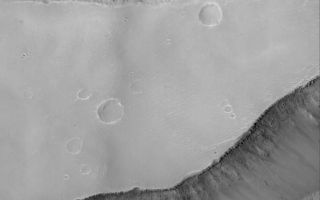 <h1>PIA06796:  Sirenum Fossae Troughs</h1><div class="PIA06796" lang="en" style="width:561px;text-align:left;margin:auto;background-color:#000;padding:10px;max-height:150px;overflow:auto;"><p>07 August 2004<br />The springtime retreat of the north polar seasonal frost cap is progressing on schedule. This Mars Global Surveyor (MGS) Mars Orbiter Camera (MOC) image shows the state of defrosting north polar sand dunes just three days ago on 3 August 2004. Dark areas on the dunes are patches of bare sand; bright areas are remnants of frost deposited during the previous winter. Summer will arrive on 20 September 2004. These dunes are located near 76.3°N, 263.5°W. Their steepest slopes, known as the slip face of each dune, point toward the northeast (upper right), indicating wind transport of sand from the southwest (lower left). The image covers an area about 3 km (1.9 mi) across and is illuminated by sunlight from the lower left.</p><br /><br /><a href="http://photojournal.jpl.nasa.gov/catalog/PIA06796" onclick="window.open(this.href); return false;" title="Voir l'image 	 PIA06796:  Sirenum Fossae Troughs	  sur le site de la NASA">Voir l'image 	 PIA06796:  Sirenum Fossae Troughs	  sur le site de la NASA.</a></div>