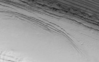 <h1>PIA06811:  Polar Unconformity</h1><div class="PIA06811" lang="en" style="width:515px;text-align:left;margin:auto;background-color:#000;padding:10px;max-height:150px;overflow:auto;"><a href="/figures/PIA06811_fig1.jpg"></a><br>Figure 1</p><p>19 August 2004<br />The arrows (see Figure 1) in this July 2004 Mars Global Surveyor (MGS) Mars Orbiter Camera (MOC) image indicate the location of an unconformity in the layered sequence of the martian north polar cap. An unconformity is a geologic term that indicates a break in the depositional record of a sedimentary deposit. In this case, the change is recorded by the presence of a series of polar layers that are truncated (cut off) along the line of arrows. The erosion that cut these layers along a gentle slope were later covered by a new set of layers that occur from the arrow tips upward to the top of the sequence shown here. The image is located near 85.2°N, 7.3°W. The bright features in the lower third of the image are frost-covered sand dunes. The image covers an area about 3 km (1.9 mi) across and sunlight illuminates the scene from the top/upper right.</p><br /><br /><a href="http://photojournal.jpl.nasa.gov/catalog/PIA06811" onclick="window.open(this.href); return false;" title="Voir l'image 	 PIA06811:  Polar Unconformity	  sur le site de la NASA">Voir l'image 	 PIA06811:  Polar Unconformity	  sur le site de la NASA.</a></div>