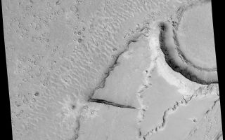<h1>PIA06878:  Megaripples in Athabasca Vallis</h1><div class="PIA06878" lang="en" style="width:800px;text-align:left;margin:auto;background-color:#000;padding:10px;max-height:150px;overflow:auto;"><a href="/figures/PIA06878_fig1.jpg"></a><br>Figure 1</p><p>Researchers' goal in taking this image was to look for boulders in the large ripples formed by an ancient catastrophic flood in Mars' Athabasca Vallis. The Mars Orbiter Camera on NASA's Mars Global Surveyor spacecraft captured this image on Dec. 25, 2003, with use of an enhanced-resolution technique called compensated pitch and roll targeted observation.</p><p>The flood-deposited megaripples had been seen in earlier, lower-resolution images from the same camera. They are the only good examples known of ripples formed in a giant catastrophic flood anywhere on Mars. Their presence indicates that large amounts of water poured rapidly through this area, based on resemblance to similar megaripples in catastrophic flood sites on Earth. The ripples in Athabasca Vallis were buried for some period and later exhumed. Strange, round features on top of some of the ripples and the adjacent plains are products of erosion and removal of the overlying layer. Finding boulders in the ripples would help constrain estimates of the power of the floods. However, the image does not show boulders in the ripples, implying either that the rocks that make up these features are smaller than about 1 to 2 meters (3 to 7 feet) in diameter or that the ripple sediments have not been completely exhumed.</p><p>The image covers an area 3 kilometers (2 miles) wide, near 9.5 degrees north latitude and 203.7 degrees west longitude. Pixel size is about 1.5 meters (5 feet) by one-half meter (1.6 feet). North is up and sunlight illuminates the scene from the lower left. </p><p>Mars Global Surveyor is managed by NASA's Jet Propulsion Laboratory, a division of the California Institute of Technology, Pasadena, for the NASA Science Mission Directorate, Washington.</p><br /><br /><a href="http://photojournal.jpl.nasa.gov/catalog/PIA06878" onclick="window.open(this.href); return false;" title="Voir l'image 	 PIA06878:  Megaripples in Athabasca Vallis	  sur le site de la NASA">Voir l'image 	 PIA06878:  Megaripples in Athabasca Vallis	  sur le site de la NASA.</a></div>