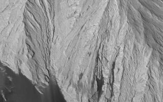 <h1>PIA06883:  East Candor Rocks</h1><div class="PIA06883" lang="en" style="width:573px;text-align:left;margin:auto;background-color:#000;padding:10px;max-height:150px;overflow:auto;"><p>24 September 2004<br />This Mars Global Surveyor (MGS) Mars Orbiter Camera (MOC) image shows a thick, massive outcrop of light-toned rock exposed within eastern Candor Chasma, part of the vast Valles Marineris trough system. Dark, windblown sand has banked against the lower outcrop slopes. Outcrops such as this in the Valles Marineris chasms have been known since Mariner 9 images were obtained in 1972. However, the debate as to whether these represent sedimentary or igneous rocks has not been settled within the Mars science community. In either case, they have the physical properties of sedimentary rock (that is, they are formed of fine-grained materials), but some igneous rocks made up of volcanic ash may also exhibit these properties. This image is located near 7.8°S, 65.3°W, and covers an area approximately 3 km (1.9 mi) across. The scene is illuminated by sunlight from the lower left.</p><br /><br /><a href="http://photojournal.jpl.nasa.gov/catalog/PIA06883" onclick="window.open(this.href); return false;" title="Voir l'image 	 PIA06883:  East Candor Rocks	  sur le site de la NASA">Voir l'image 	 PIA06883:  East Candor Rocks	  sur le site de la NASA.</a></div>